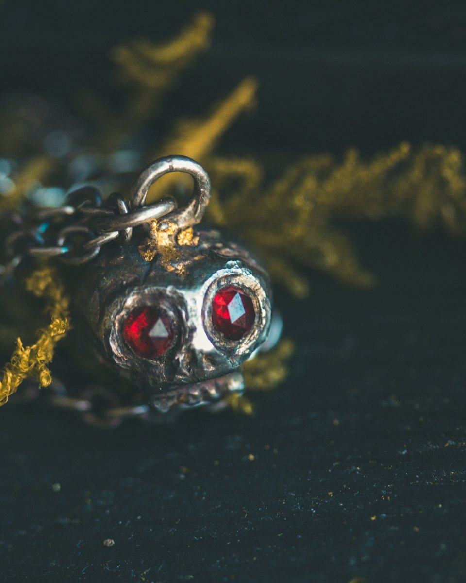 Memento Mori Skull Charm with Almandine Garnet Eyes – Sterling Silver & 23.5K Gold | Talisman of Life, Death, and Deep Transformation - Machinations
