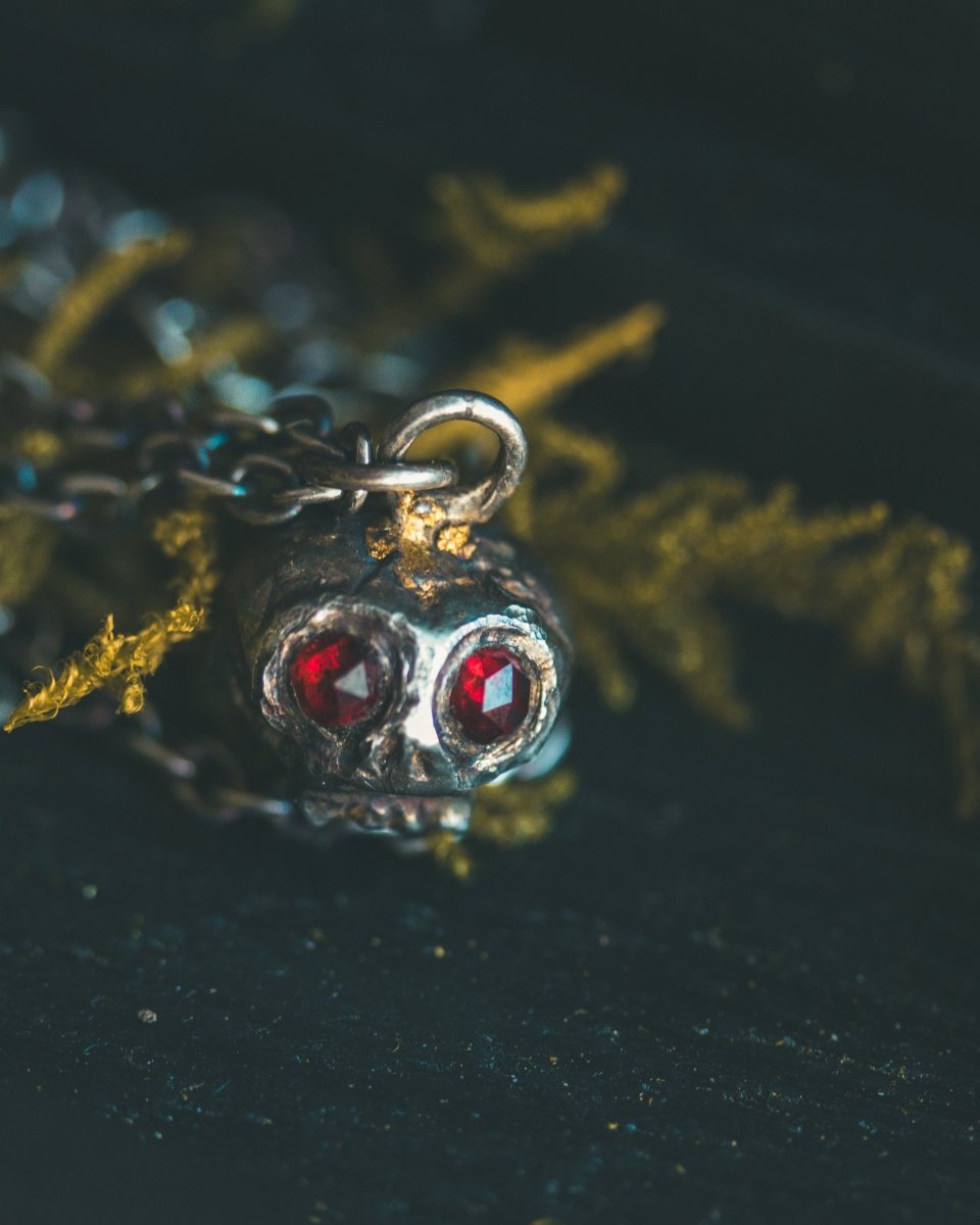 Memento Mori Skull Charm with Almandine Garnet Eyes – Sterling Silver & 23.5K Gold | Talisman of Life, Death, and Deep Transformation - Machinations