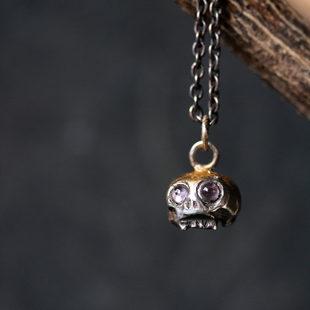Skull charm with amethyst eyes - Machinations