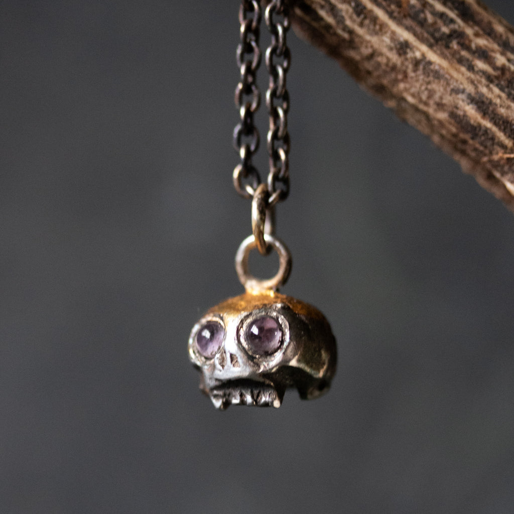 Skull charm with amethyst eyes - Machinations