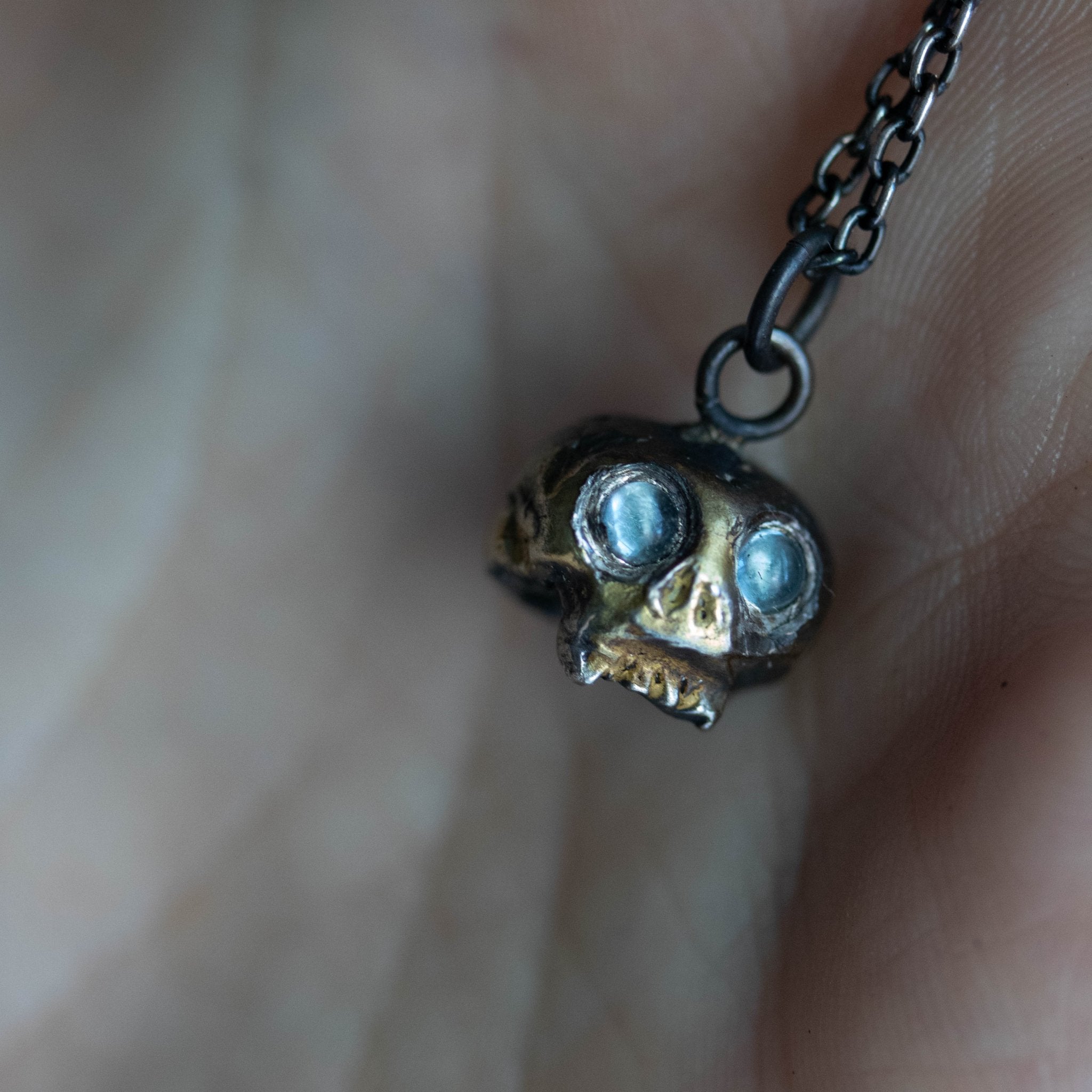 Skull charm with aquamarine eyes - Machinations