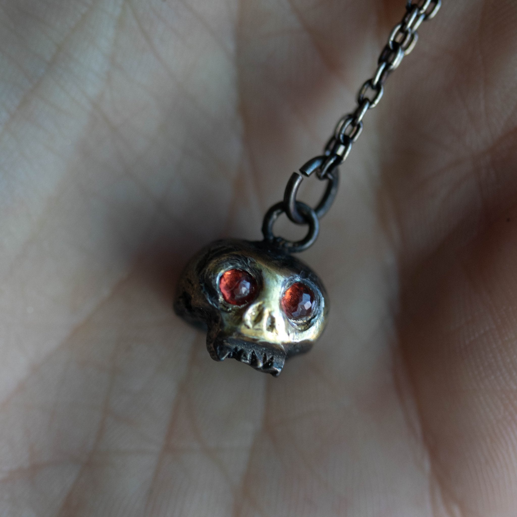 Skull charm with garnet eyes - Machinations